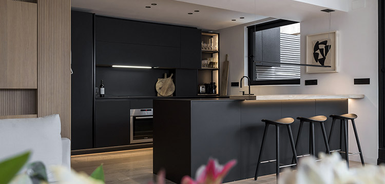 Muebles de cocina negros integrados en una cocina abierta